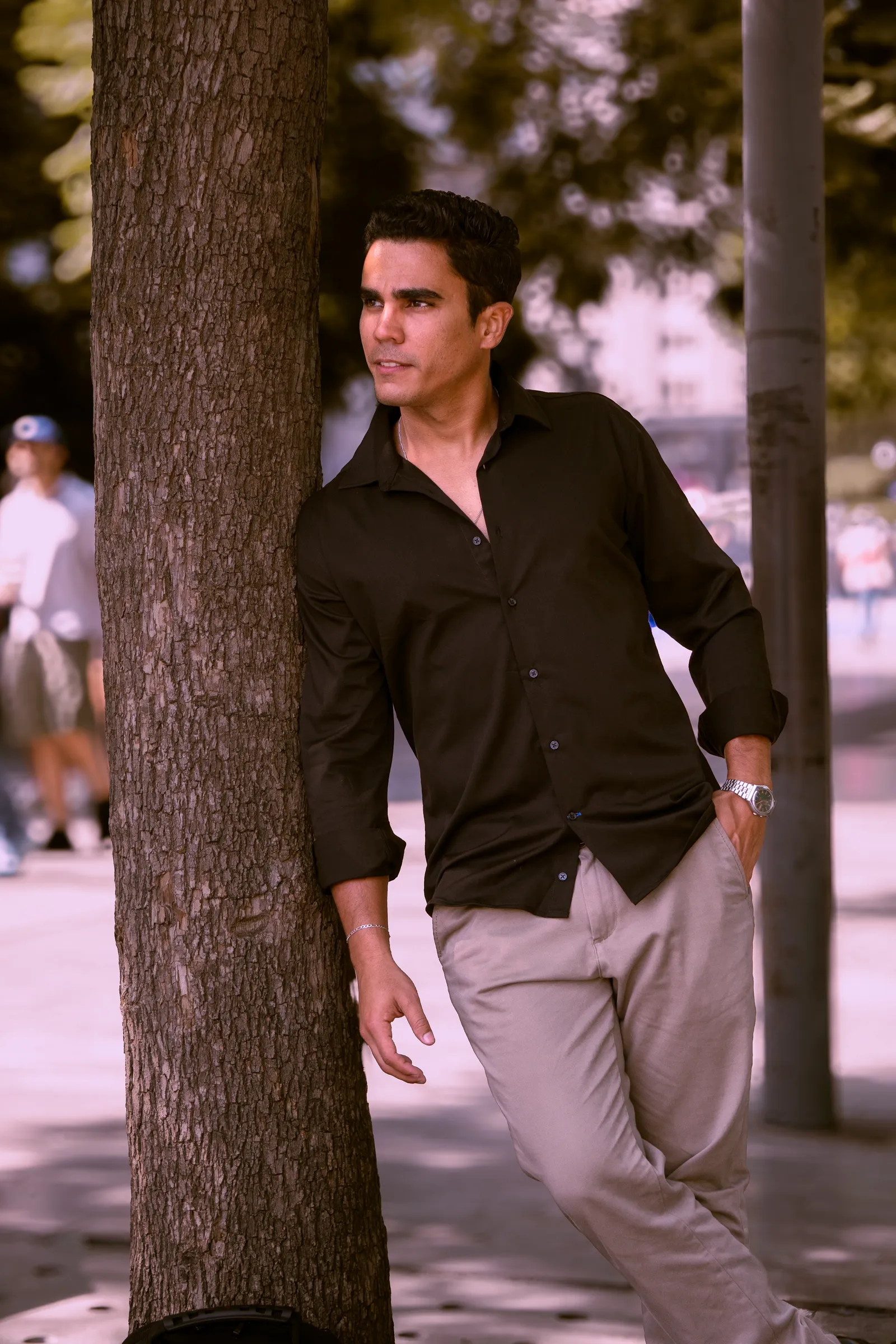 Retrato de hombre junto a un árbol en la ciudad